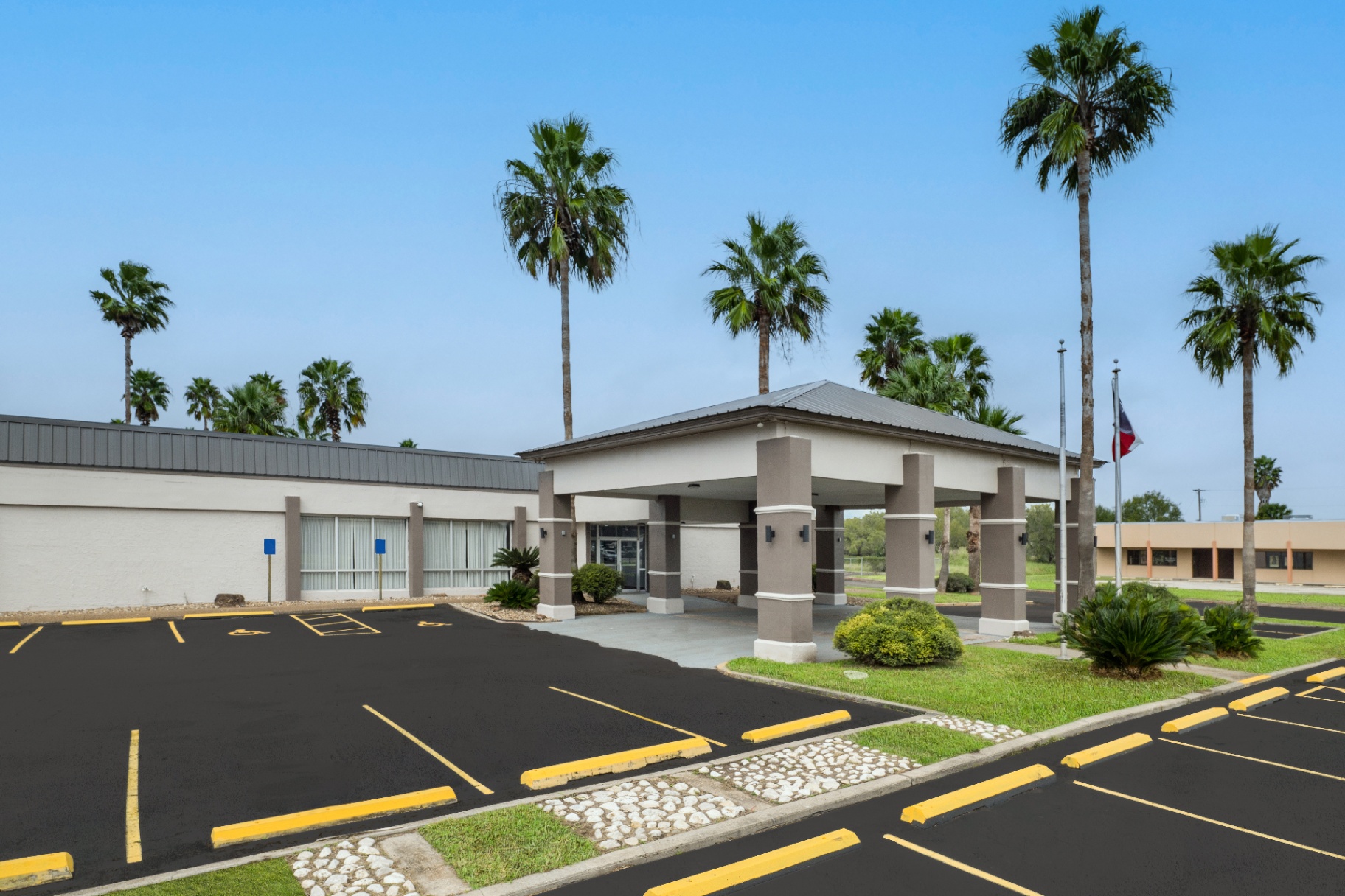 Quality Inn Alice, TX exterior with palm trees